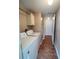Bright laundry area featuring a washer, dryer, storage cabinet, and an adjacent hallway at 222 Palmer Park Ln, Davenport, FL 33897