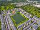Wide aerial view of the community featuring a central pond surrounded by residences and lush landscaping at 2794 Club Cortile Cir # B, Kissimmee, FL 34746