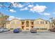Well-maintained two-story condo building featuring red doors, balconies, and ample parking in a landscaped setting at 2794 Club Cortile Cir # B, Kissimmee, FL 34746