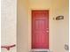 Close-up of a vibrant red front door with classic hardware, set against a neutral-toned exterior at 2794 Club Cortile Cir # B, Kissimmee, FL 34746