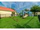 Fun, fenced playground featuring a slide, climbing structure, and a seesaw on artificial grass at 2794 Club Cortile Cir # B, Kissimmee, FL 34746
