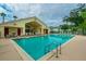 Inviting community pool and clubhouse with lounge chairs and umbrellas for relaxing by the water at 2794 Club Cortile Cir # B, Kissimmee, FL 34746