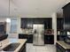 Kitchen boasts granite countertops, stainless steel appliances, and black cabinets at 3100 Rocky River Rd, Kissimmee, FL 34746