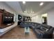 Bright living room featuring modern decor, wood-look floors, a sectional sofa, and a contemporary entertainment center at 3100 Rocky River Rd, Kissimmee, FL 34746