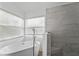 Bright bathroom featuring a sleek, modern tub and tiled walk-in shower with natural light at 3193 Verbena Ct, Deltona, FL 32725