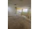 Second story hallway overlooking the living area with carpet floors and a large window at 3557 Valleyview Dr, Kissimmee, FL 34746