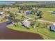 Wide aerial view showcasing a beautiful lakeside property with manicured lawns and mature landscaping at 3607 Hidden River Ln, Tavares, FL 32778