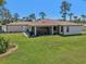 Spacious backyard featuring a well-maintained lawn, screened lanai, and exterior access door at 3607 Hidden River Ln, Tavares, FL 32778