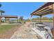 Backyard with outdoor kitchen, stone path, lake, fire pit, and picnic table at 3607 Hidden River Ln, Tavares, FL 32778