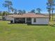 Backyard view with a well-kept lawn, screened porch, and classic neutral siding at 3607 Hidden River Ln, Tavares, FL 32778
