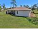 Backyard view of home featuring a spacious lawn, neutral siding, and screened-in porch at 3607 Hidden River Ln, Tavares, FL 32778