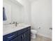 Chic half bathroom featuring a navy blue vanity and a white marble countertop at 3607 Hidden River Ln, Tavares, FL 32778