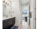 Hallway bathroom featuring a dark vanity with white countertop and tiled floors at 3607 Hidden River Ln, Tavares, FL 32778