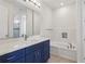 Bright bathroom featuring blue vanity with white countertops and a bathtub with stylish tile accents at 3607 Hidden River Ln, Tavares, FL 32778