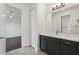 Well-lit bathroom with a dark vanity, white countertop, and tile flooring; view to connecting bedroom at 3607 Hidden River Ln, Tavares, FL 32778