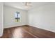 Empty bedroom with hardwood floors, a ceiling fan, and a window showcasing the landscape at 3607 Hidden River Ln, Tavares, FL 32778