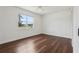 Bright, empty bedroom with a ceiling fan, hardwood floors, and a large window showcasing the landscape at 3607 Hidden River Ln, Tavares, FL 32778