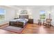 Inviting bedroom featuring hardwood floors, a cozy rocking chair, and picturesque window views at 3607 Hidden River Ln, Tavares, FL 32778