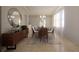 Elegant dining room with a wood sideboard, round mirror, and stylish table setting, illuminated by modern chandelier at 3607 Hidden River Ln, Tavares, FL 32778