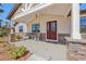 Inviting front porch featuring stone accents, a cozy seating area, and an elegant front door at 3607 Hidden River Ln, Tavares, FL 32778