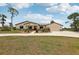 Charming one-story home featuring a manicured lawn, colorful landscaping, and a large driveway with an attached garage at 3607 Hidden River Ln, Tavares, FL 32778