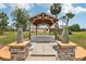 Outdoor gazebo with stone pillars, a paver walkway and lush landscaping at 3607 Hidden River Ln, Tavares, FL 32778