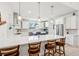 Bright kitchen with stainless appliances, white cabinets, a blue accent island and an island with barstool seating at 3607 Hidden River Ln, Tavares, FL 32778