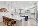 Bright kitchen with stainless appliances, white cabinets, a blue accent island and an island with barstool seating at 3607 Hidden River Ln, Tavares, FL 32778
