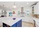 This kitchen features white cabinetry, a blue island, stainless appliances and a decorative backsplash at 3607 Hidden River Ln, Tavares, FL 32778