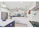 Open-concept kitchen with stainless appliances, white cabinets, and island seating that opens up to the living room at 3607 Hidden River Ln, Tavares, FL 32778