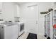 Well-equipped laundry room with modern appliances, storage cabinets, and tile flooring at 3607 Hidden River Ln, Tavares, FL 32778