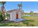 Charming shed by the pond with a decorative door and ample storage space at 3607 Hidden River Ln, Tavares, FL 32778