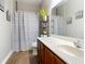 Neutral bathroom featuring wood cabinets, patterned shower curtain, and a large mirror at 3709 Cedar Hammock Trl, St Cloud, FL 34772