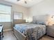 Bright bedroom with a large window, light wood flooring, and a dresser with a mirror at 3709 Cedar Hammock Trl, St Cloud, FL 34772
