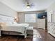 Well-lit bedroom with dark wood floors, modern bed and dresser, and ceiling fan at 3709 Cedar Hammock Trl, St Cloud, FL 34772