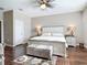 Spacious bedroom with neutral paint, ceiling fan, wooden floors, and a comfortable ottoman at 3709 Cedar Hammock Trl, St Cloud, FL 34772