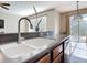 Kitchen peninsula with stainless faucet, undermount sink, granite countertop, and view to backyard at 3709 Cedar Hammock Trl, St Cloud, FL 34772
