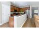 Open concept kitchen with peninsula overlooking the living room featuring modern appliances and wood cabinets at 3709 Cedar Hammock Trl, St Cloud, FL 34772
