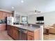 Open concept kitchen with peninsula overlooking the living room featuring modern appliances and wood cabinets at 3709 Cedar Hammock Trl, St Cloud, FL 34772