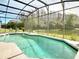 Beautiful screened-in pool overlooking a scenic pond and lush greenery at 3709 Cedar Hammock Trl, St Cloud, FL 34772