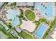 A luxurious community pool area features multiple pools, a volleyball court, and lush tropical landscaping at 7059 Nemours Pkwy, Orlando, FL 32827