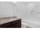 A bathroom vanity with a granite countertop, a large mirror, and a shower-tub combo with white tiles at 7059 Nemours Pkwy, Orlando, FL 32827