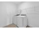 Bright laundry room features modern, front-loading washer and dryer plus wire shelving for storage at 7059 Nemours Pkwy, Orlando, FL 32827