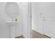 Clean powder room featuring a pedestal sink with a round mirror and tile flooring at 7059 Nemours Pkwy, Orlando, FL 32827