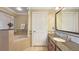 Bathroom featuring tile flooring, a soaking tub, granite countertops, and wood cabinets at 7673 Heritage Crossing Way # 301, Reunion, FL 34747