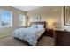 Cozy bedroom featuring a queen-sized bed with floral bedding, neutral walls, and two windows for natural light at 7673 Heritage Crossing Way # 301, Reunion, FL 34747