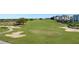 Beautifully manicured golf course featuring lush green fairways, sand traps, and distant community buildings at 7673 Heritage Crossing Way # 301, Reunion, FL 34747