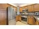 Modern kitchen with stainless steel appliances, wooden cabinets, and tile backsplash with granite countertops at 7673 Heritage Crossing Way # 301, Reunion, FL 34747