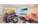 Bright living room with hardwood floors, comfortable seating, and a view into the kitchen and dining area at 7673 Heritage Crossing Way # 301, Reunion, FL 34747