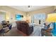 Comfortable living room featuring a ceiling fan, tile flooring, and French doors leading to the balcony at 7673 Heritage Crossing Way # 301, Reunion, FL 34747